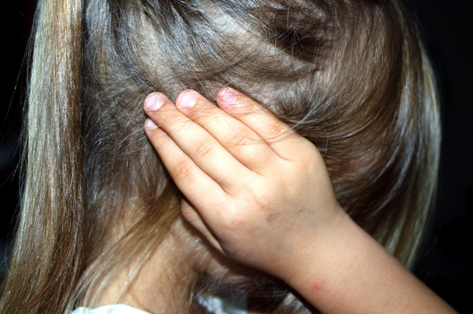 Child with hands over ears