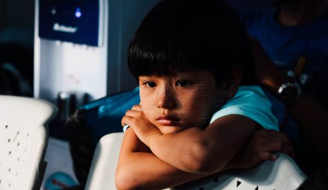 childlookingunhappy_960 Child leaning on the back of a chair looking unhappy
