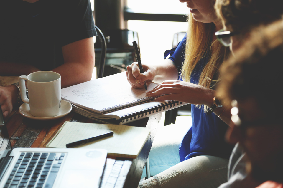 People gathered close around a table on a coffee meeting