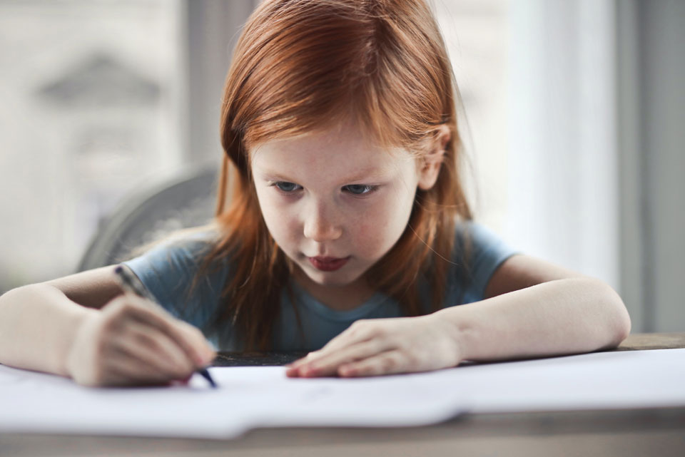 young girl writing in a book