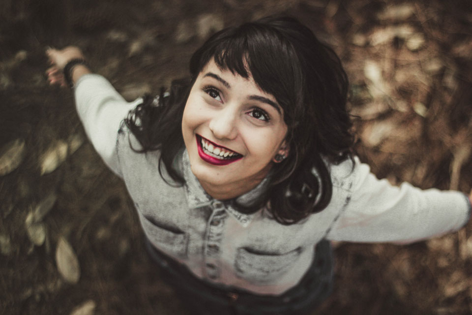 Young girl looking up very happily to the sky