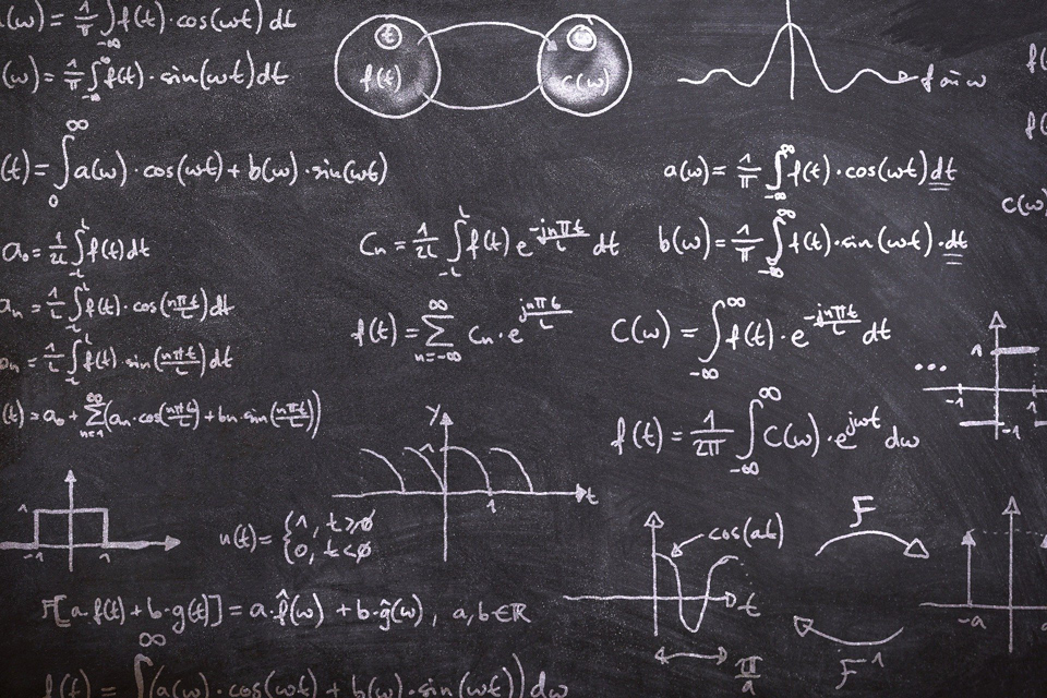 Photo of a blackboard full of complicated maths formulas