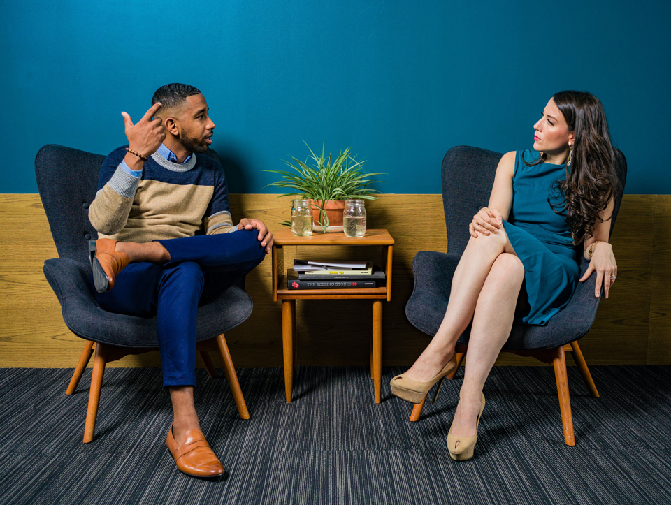 Man talking in an animated fashion to a woman who is listening intently