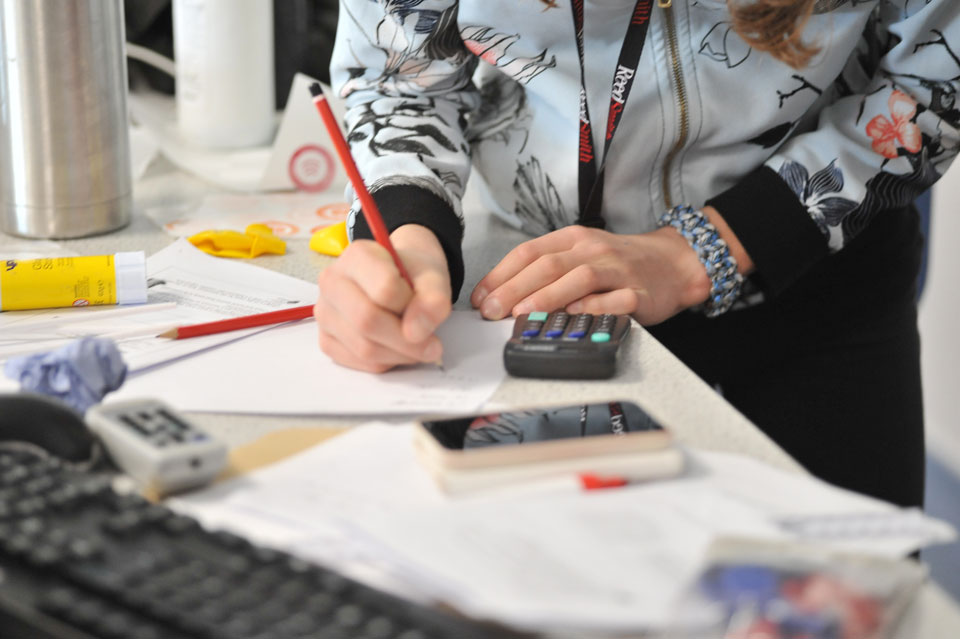 Hands of teenager using a calculator and writing