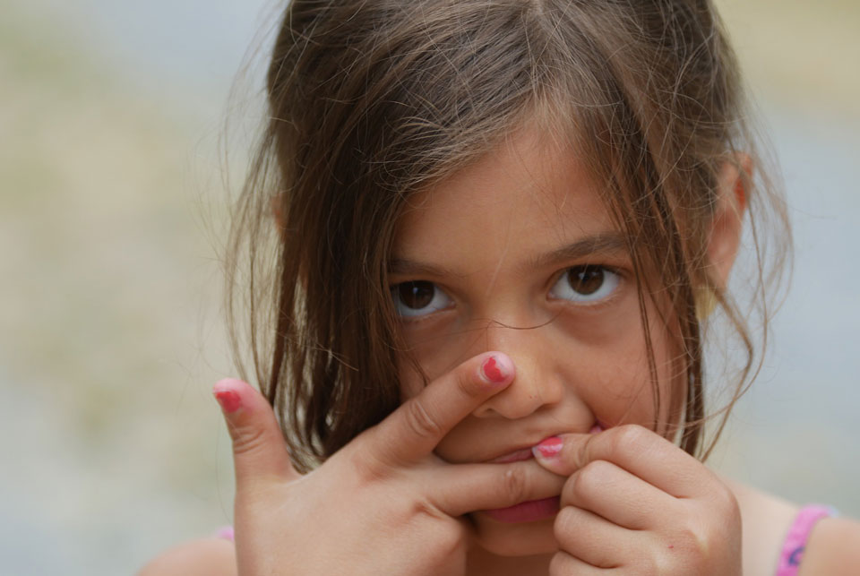 young girl biting her fingers
