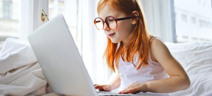 pexels-andrea-piacquadio-960 Girl sitting on a bed looking at a laptop