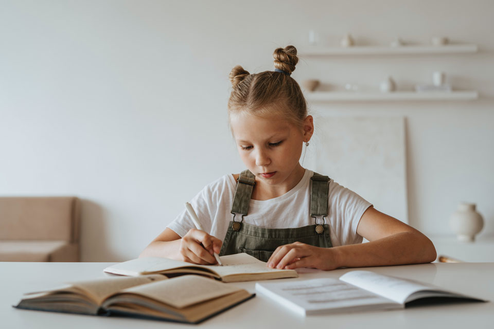 primary school aged child writing at a table