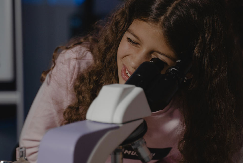 Teenager looking down a microscope