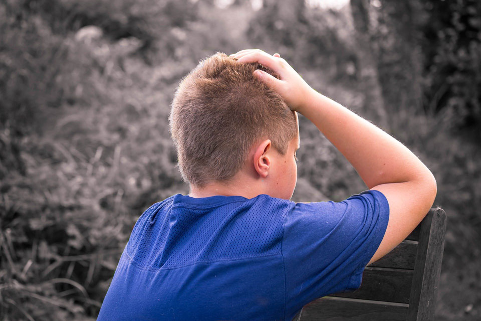 Boy holding head in hands