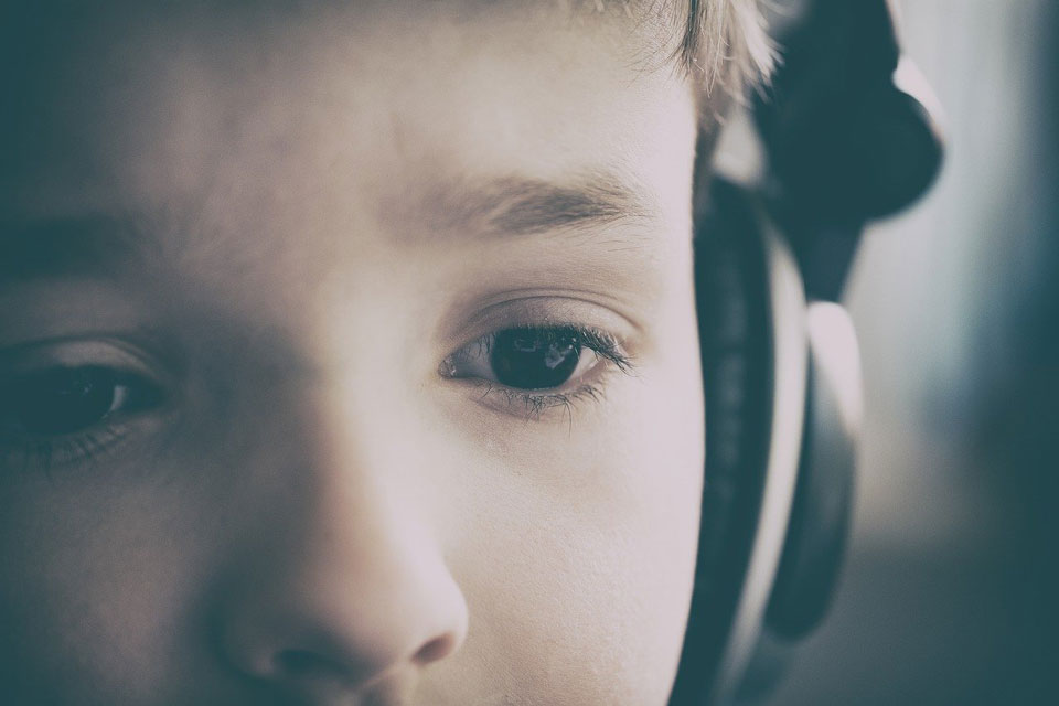 child in headphones looking slightly worried