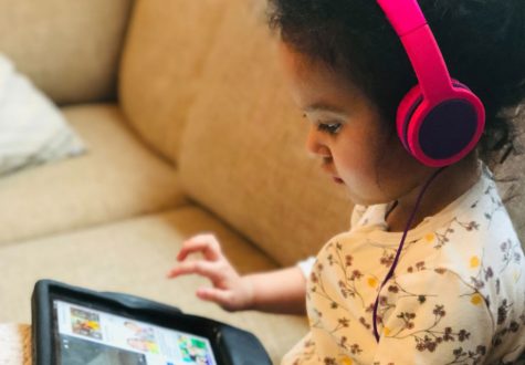 pexels-ali-smith-4124279-960 Young girl on sofa looking at a tablet, wearing headphones